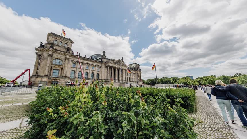 People walk in front of Berlin Reichstag