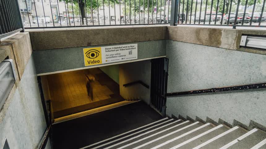 People go up and down the steps and sidewalk in busy city