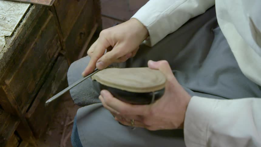 A person is shaving the edge of a shoe