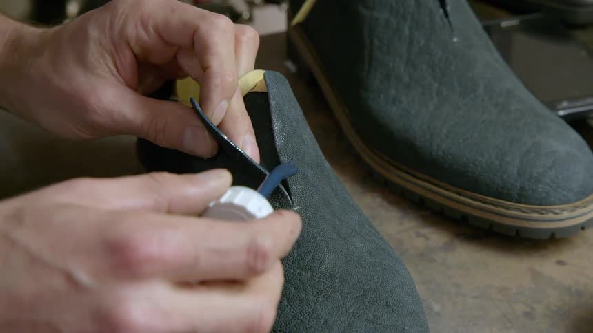 Man puts shoe polish on a shoe