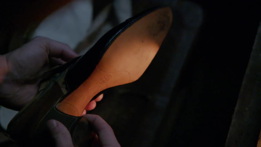 A man is examining a woman's shoe
