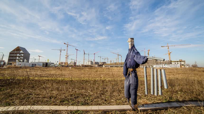Cranes turn and assemble a building