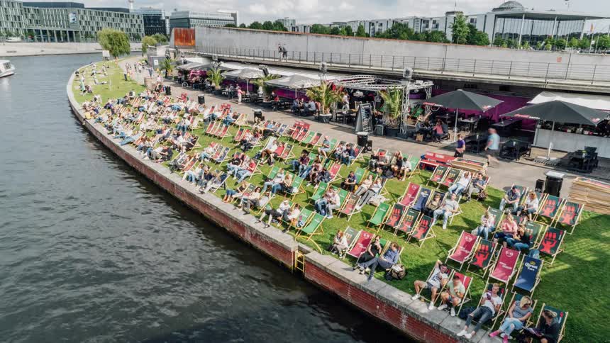 A crowd sitting near a river