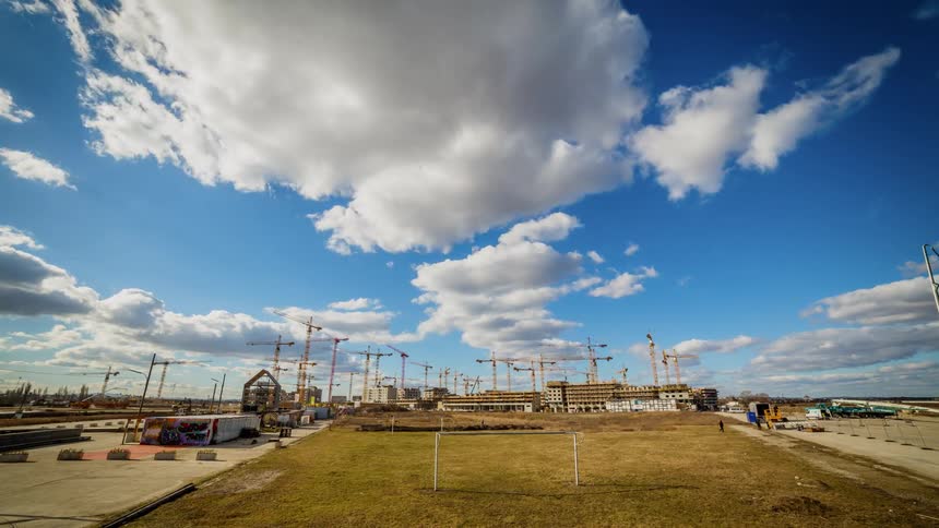 The clouds move fast over this busy work site full of cranes