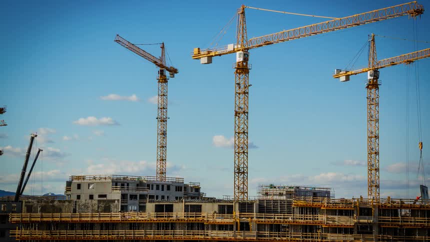 Cranes move while constructing a building