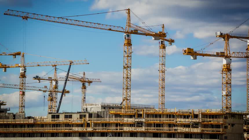 Cranes rotate over a building development