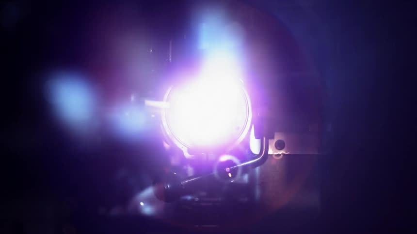 A projector is flashing lights towards the camera