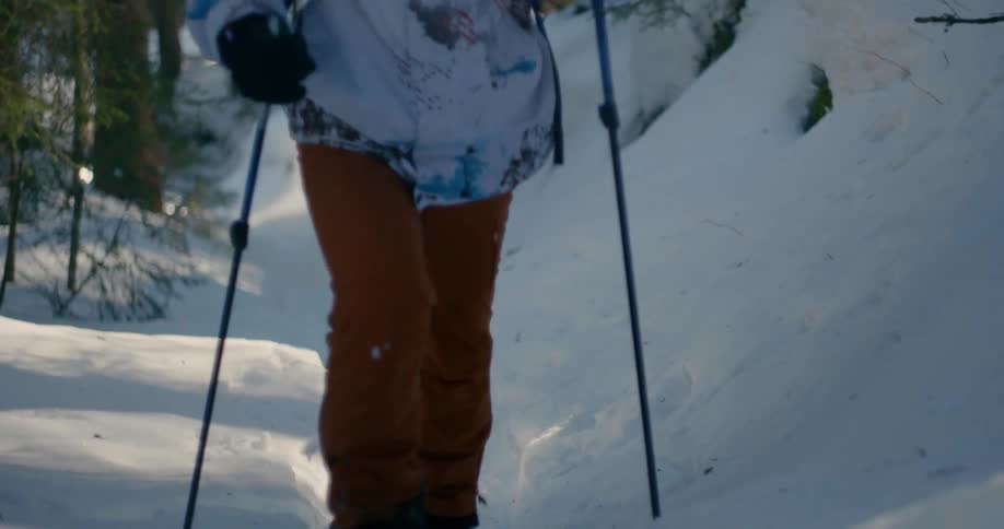 A person hikes up a snowy hill with ski shoes on