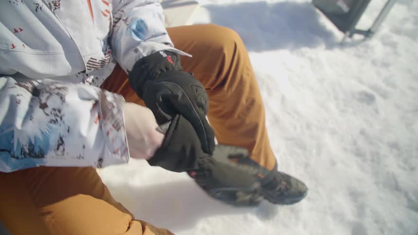 A person puts on thick gloves
