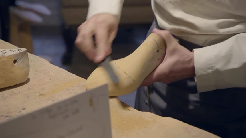 A man is carving wood in a shop fast