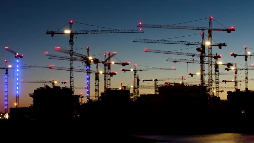 Cranes rotate over a building development