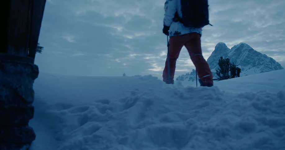 A man hikes in snowy mountains
