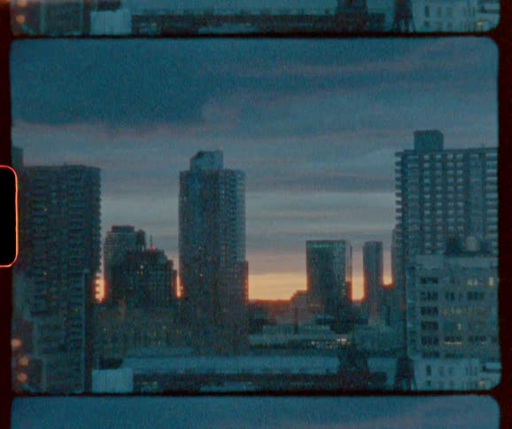 Storm clouds are hovering over a city skyline at dawn
