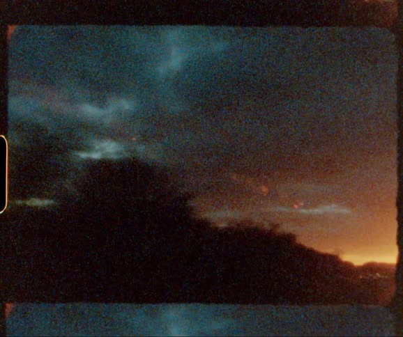 Clouds hang in the sky as the sun sets