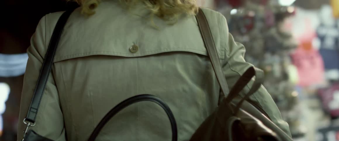 Woman walks through a city with a purse