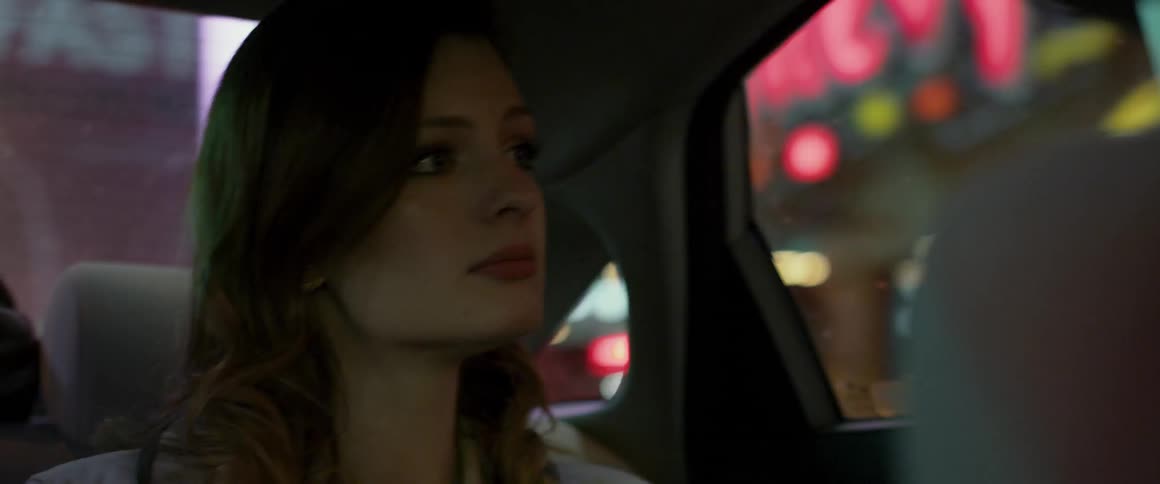 Woman rides in the back of a car