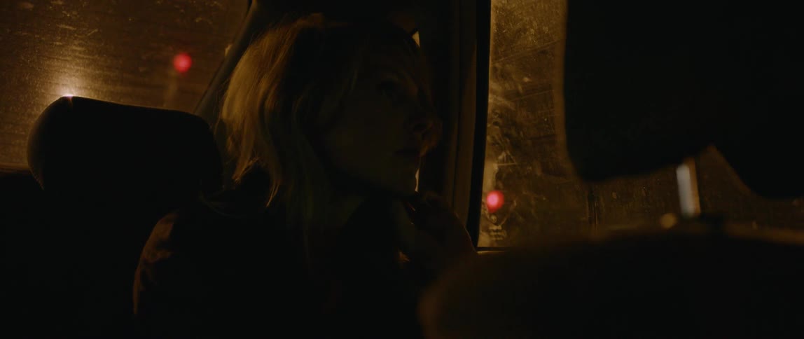 A woman rides in a vehicle at night