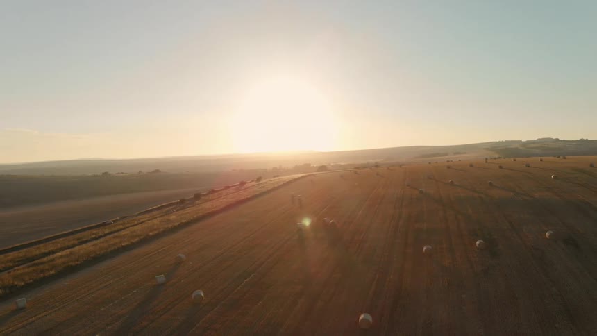 The sun is setting on some farm land