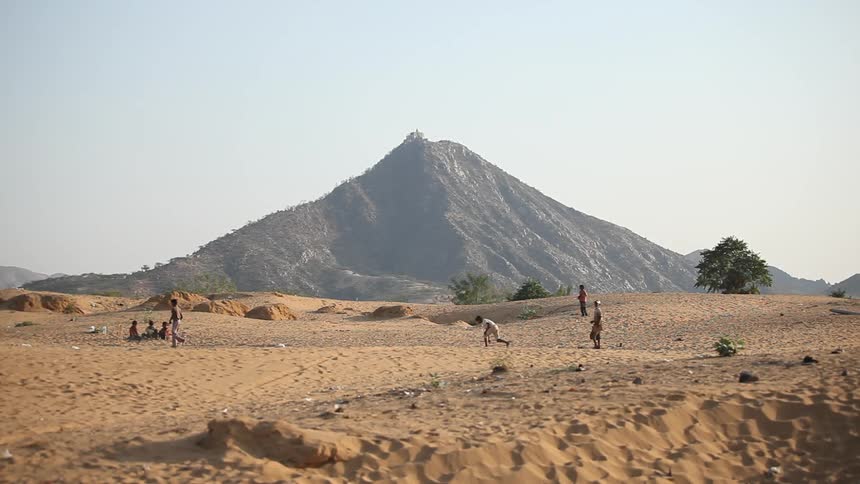Children playing cricket in the desert