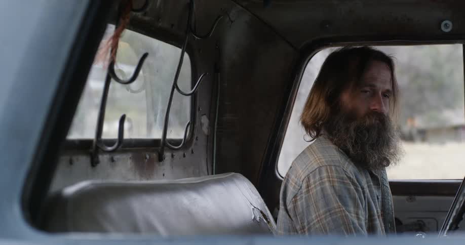 Two men are sitting in a truck and one gets out