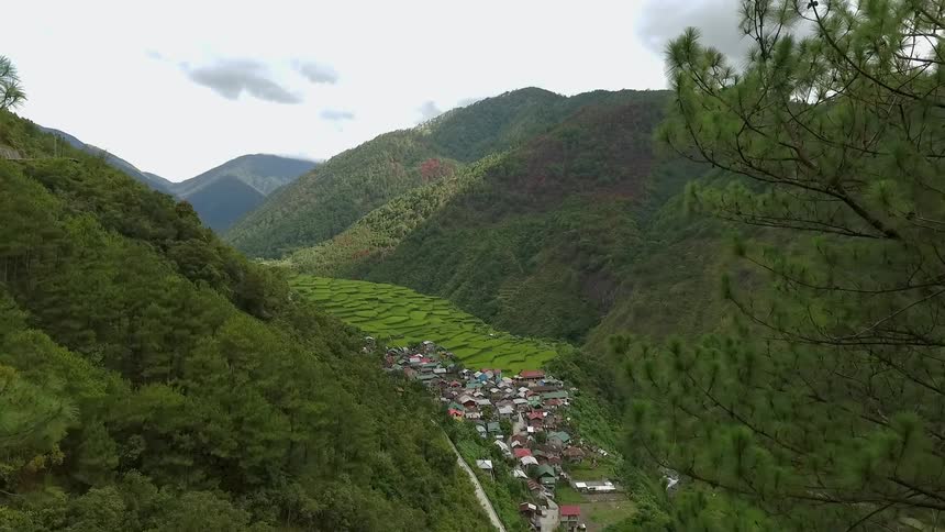 A small village is nestled in a valley between two hills