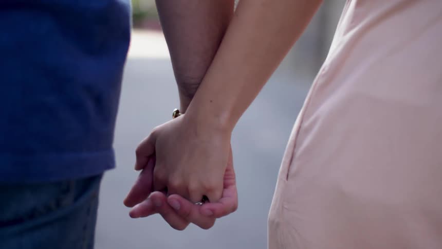 A man and woman hold hands