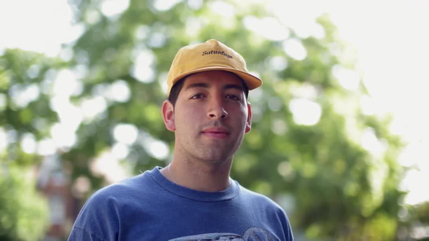 A man wearing a yellow cap smiles