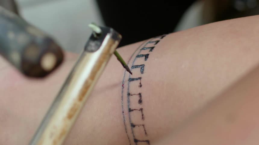 Someone getting an old school tattoo on their leg