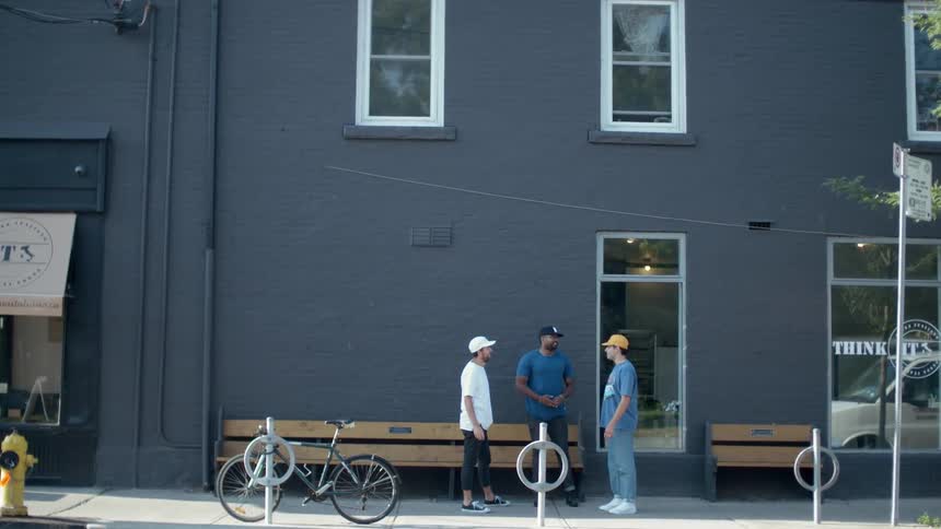 Three men are standing outside of a building