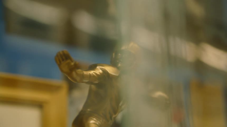 Bronze figure of a football player holding a football