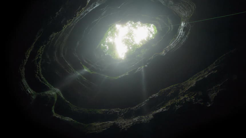 Light filters down through a deep cavern