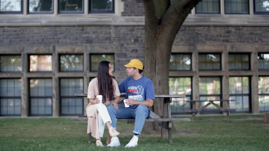 A man and woman are sitting on a park bench embracing