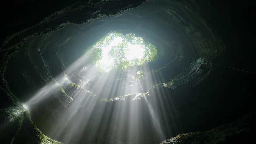 A cave with a hole in the top is viewed from below