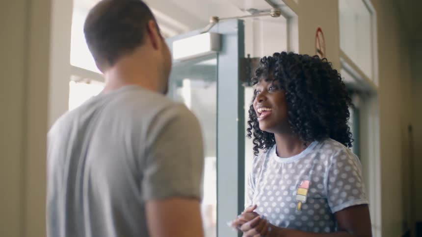 A man and woman talk inside a building