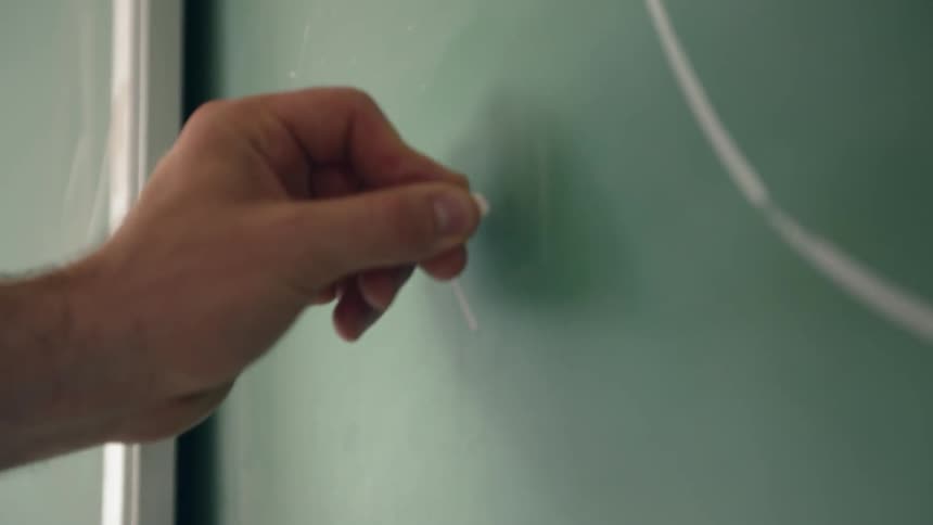 A man is drawing on a chalkboard