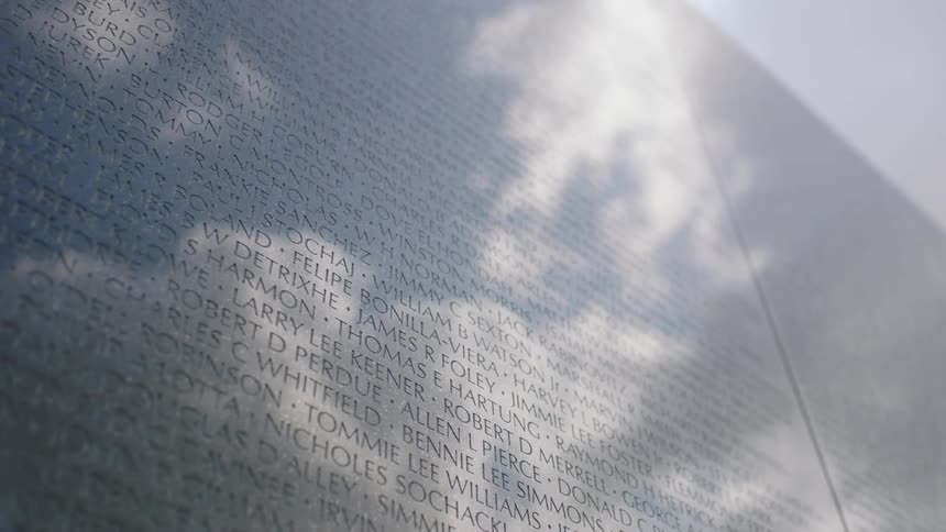 The sunshine and clouds are reflected off a military personnel tribute