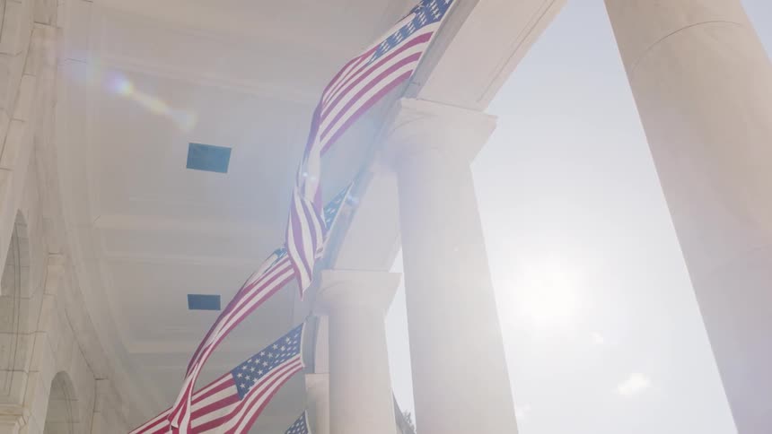 American flags breeze in the wind at a monument