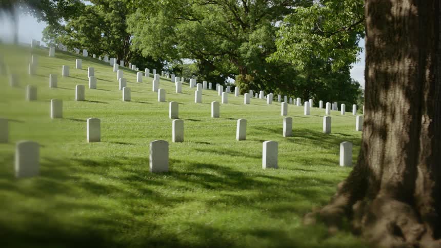 White tombstones are lined up in a graveyard