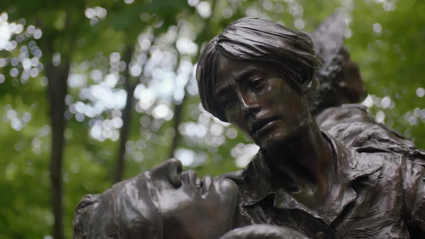 A statue commemorating soldiers sits in a park