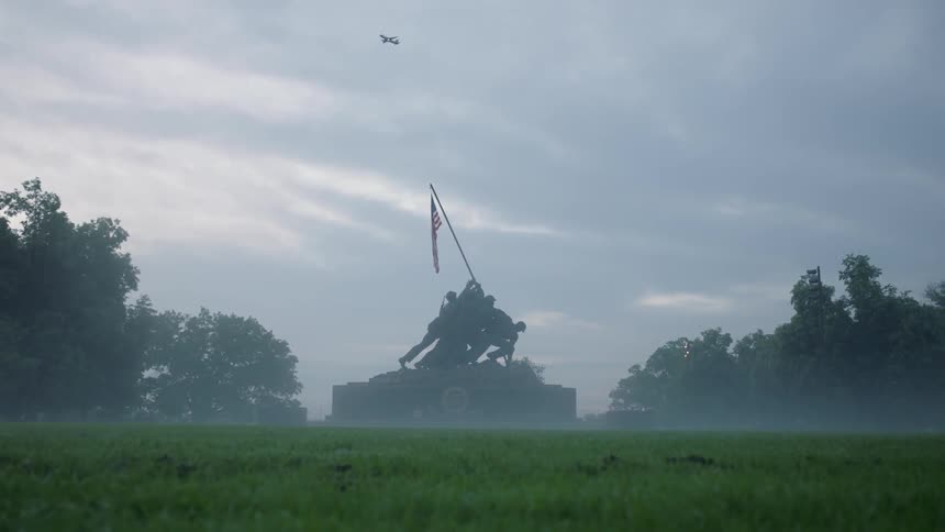 A plane is flying over a bronze monument