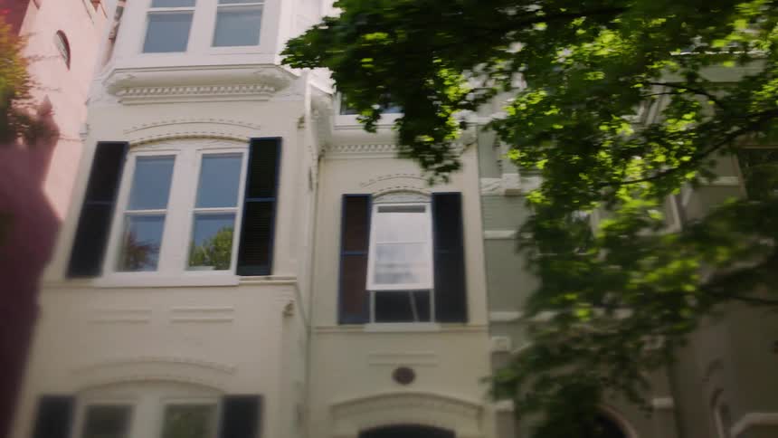 Two story houses line the side of a road