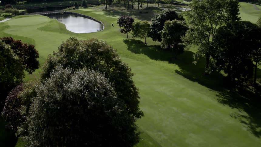 A golf course with a lake is flown over