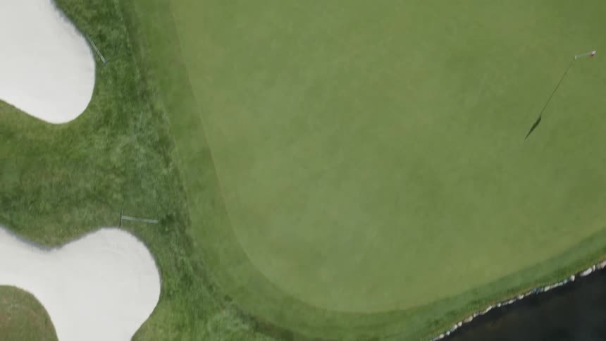 A green golf course is flown over