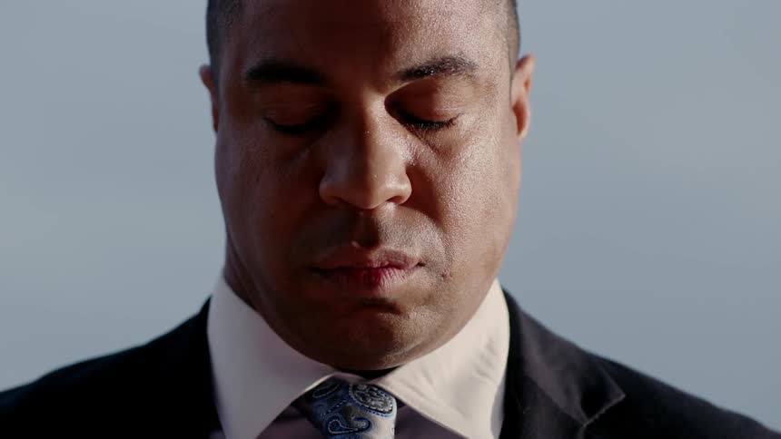 A man in a suit is looking down