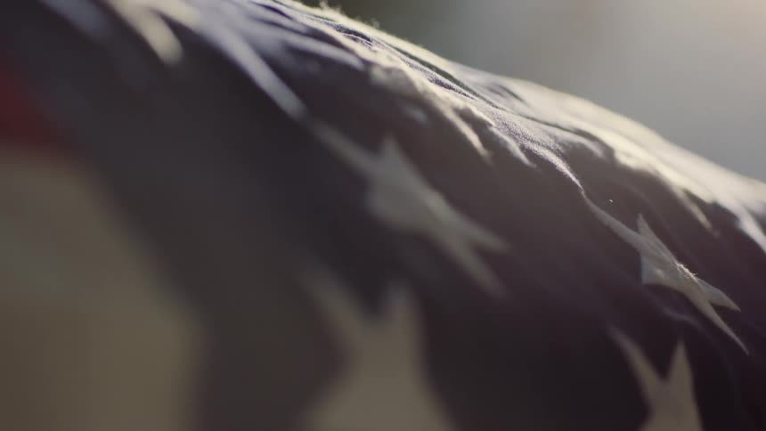An american flag is draped over a casket