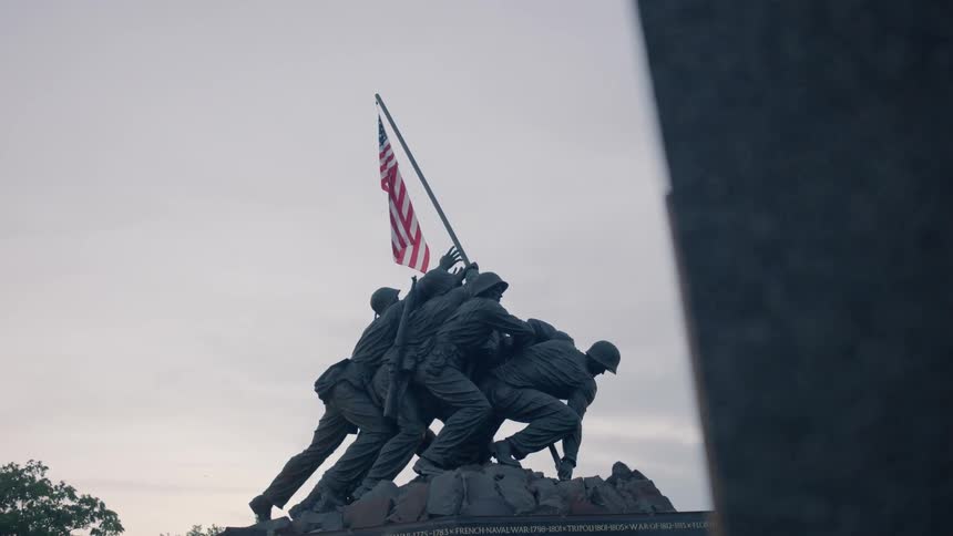 A monument of soldiers planting the american flag is shown