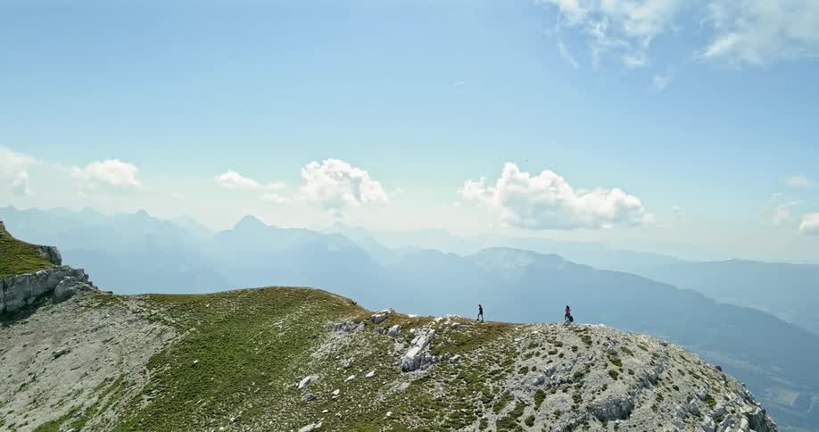 A group of people are walking on top of a mountain