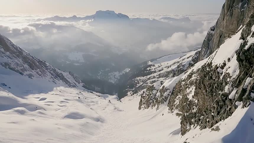 Hikers stand at the top of a snowy mountain