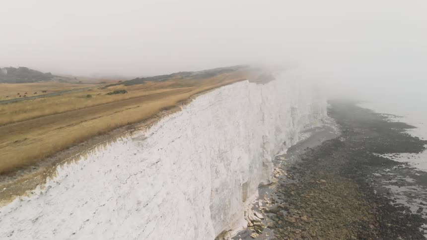 Fog rolls in over white cliffs
