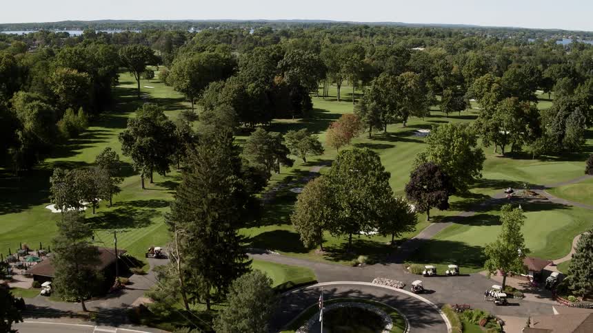 A golf course with a lot of golf carts parked